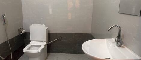 A bathroom with a toilet, a sink, and a shower.
