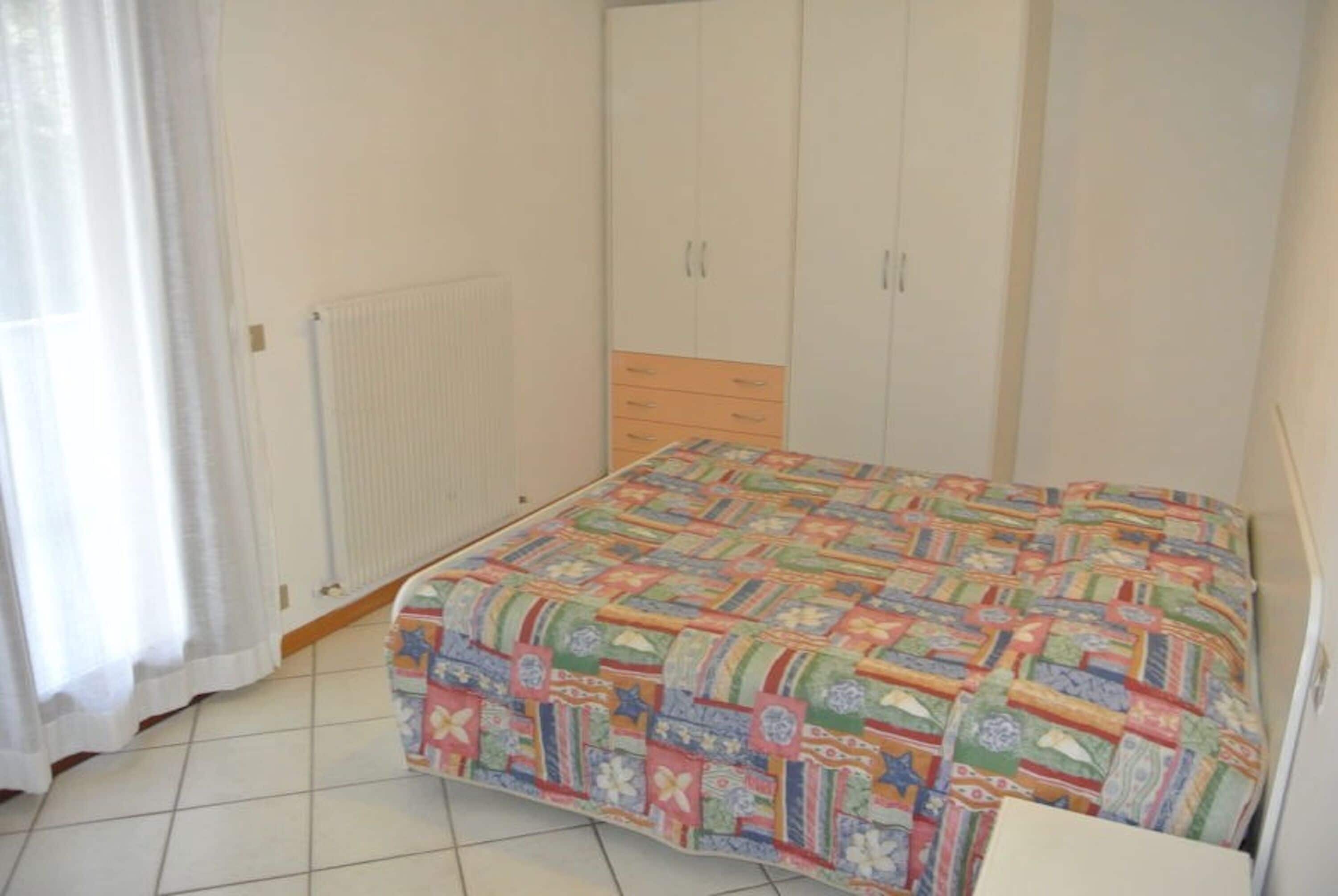 A bedroom with a bed, a wardrobe, and a radiator.