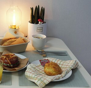 A breakfast setting with a bagel, muffin, and coffee on a table. - Experience Seoul in a quiet area, just 4 minutes from Dapsimni Station. (Seoul)