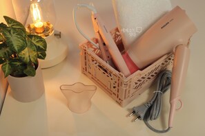A bedside table with a plant, a toothbrush holder, and a hairdryer. - Experience Seoul in a quiet area, just 4 minutes from Dapsimni Station. (Seoul)