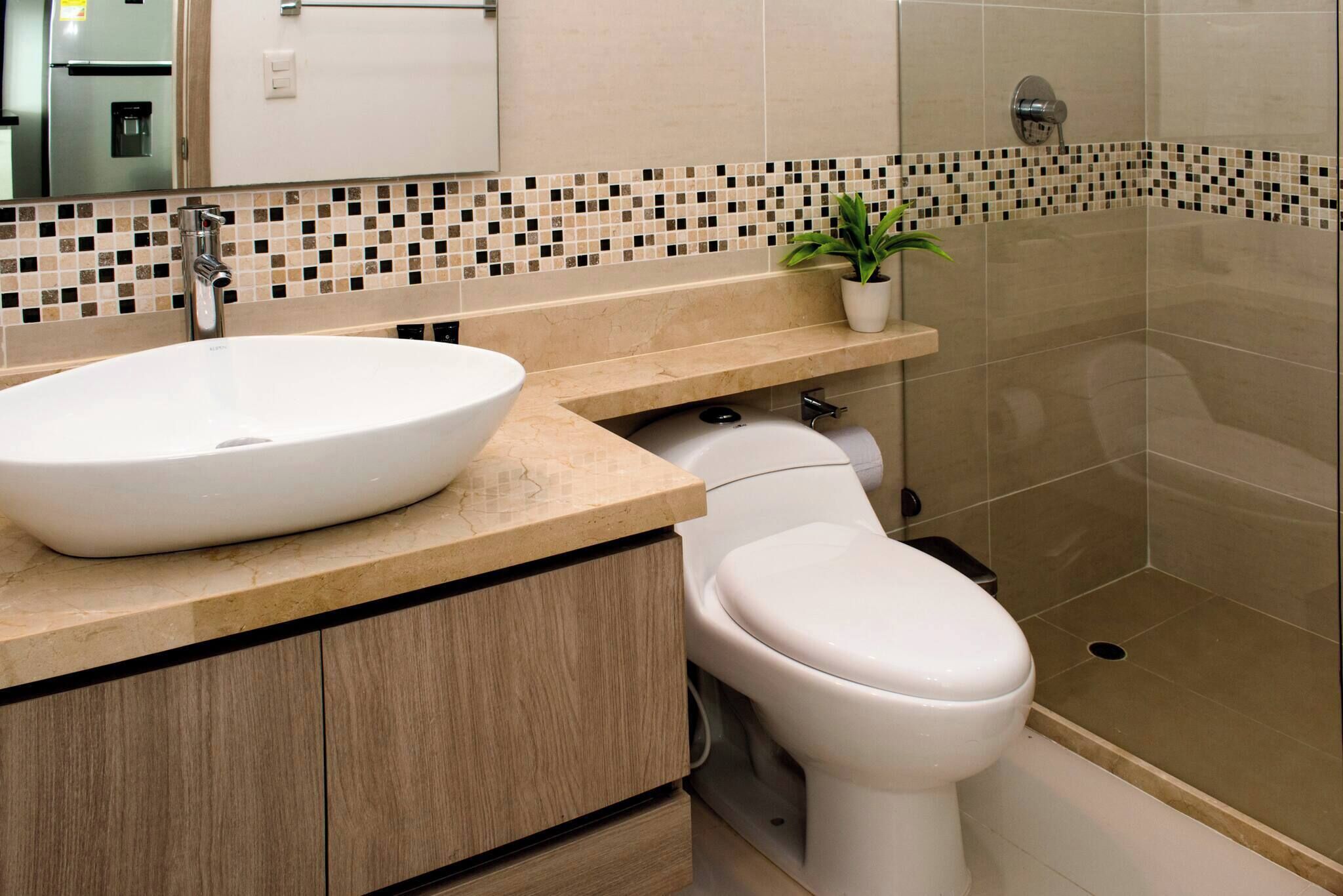 A bathroom with a white sink, toilet, and shower.