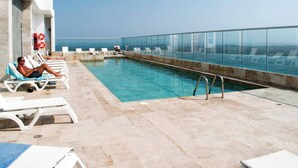 A rooftop pool with clear blue water, white lounge chairs, and a glass balustrade. - 1 Bedroom Sunset Luxury Apartment Private Jacuzzi (Cartagena)