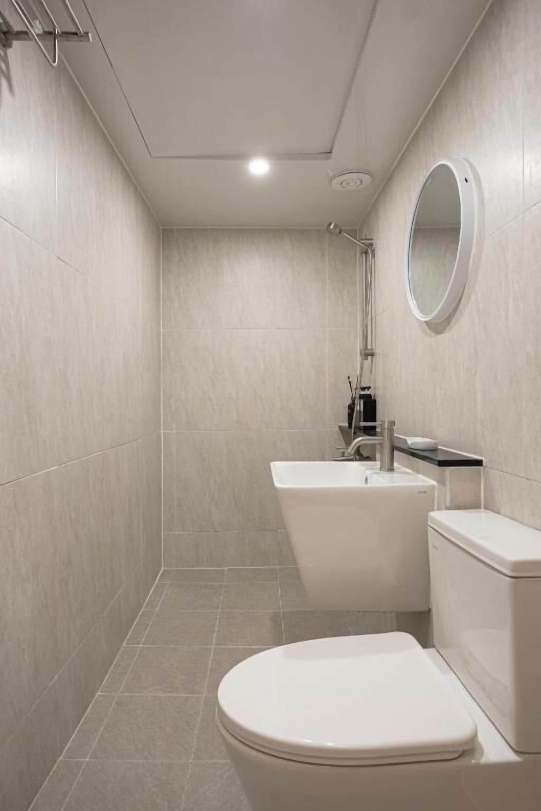 A bathroom with a toilet, sink, and shower.