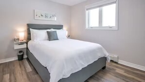 A bedroom with a bed, bedside tables, a window, and wall art. - Campfire, Privacy, Stargazing minutes to Beaches/Orillia/Casino Rama (Orillia)
