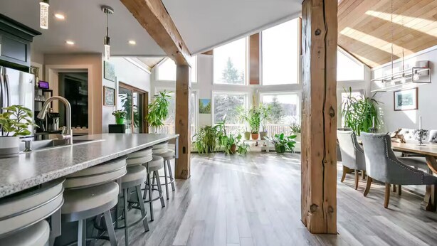 A modern kitchen with a bar area, wooden beams, and large windows. - Campfire, Privacy, Stargazing minutes to Beaches/Orillia/Casino Rama (Orillia)
