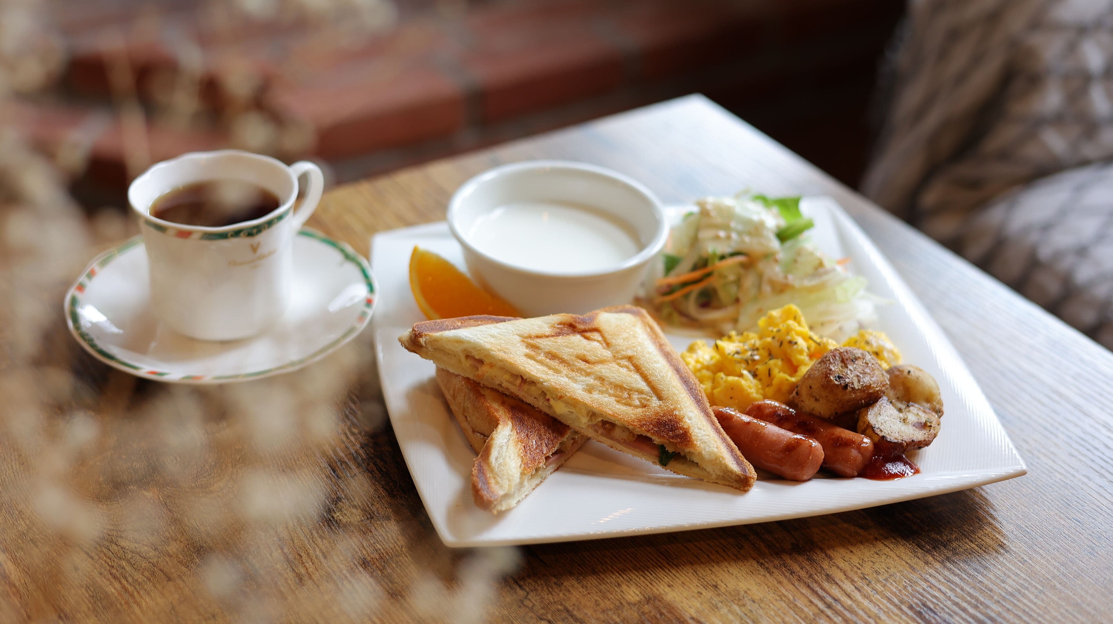 A plate of food including toast, scrambled eggs, sausages, and a side salad.