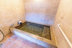 A bathtub with a tiled interior and a drain. - TOMONOWA (Bandai)