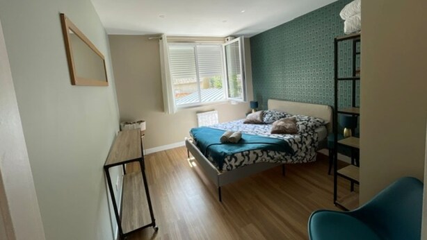 Une chambre à coucher avec un lit, un bureau, une chaise et une fenêtre.