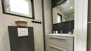 Une salle de bain avec des toilettes, un lavabo, un miroir et une fenêtre.