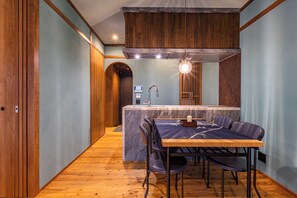 Eine moderne Küche mit einer Marmorinsel, Holzschränken und einem Essbereich mit Tisch und Stühlen.