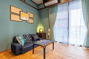 Ein Wohnzimmer mit einer Couch, einem Couchtisch und einer Wand-Klimaanlage.