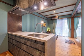 Eine moderne Küche mit einer zentralen Kochinsel, Einbau-Schränken und einem sichtbaren Spülbecken.