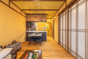 A compact living space with a dining area, kitchenette, and a sofa. - Stylish Apartment with Balcony, Walk to Dotonbori, Shinsaibashi, & Kuromon Mkt (大阪市)