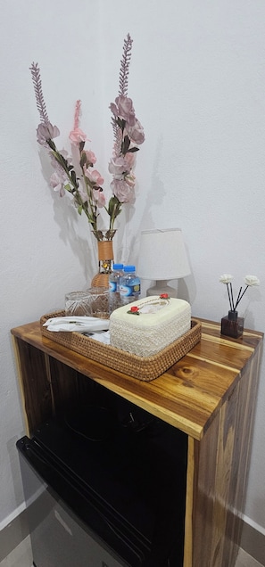 Een houten console tafel met een taart, een lamp, een vaas met bloemen en een mand.