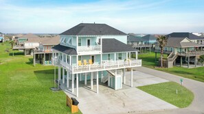 Une maison à plusieurs étages dotée d’un balcon et d’une véranda.