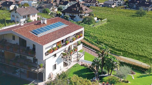 A residential area with houses, a church tower, and a vineyard. - Highlight Apartments: Ap. Harmony with garden access, loggia and Mobil Card incl. (Sankt Pauls)