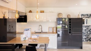 A modern kitchen with a wooden island, stainless steel appliances, and pendant lighting. - Your dream getaway just a stone's throw from the beaches of the Vendée! (Sainte-Foy)