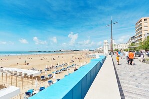A beach with sun loungers and umbrellas, a pier, and a clock tower in the background. - Your dream getaway just a stone's throw from the beaches of the Vendée! (Sainte-Foy)