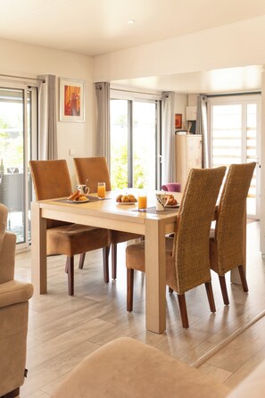 Een eetruimte met een tafel, stoelen en ontbijtartikelen.