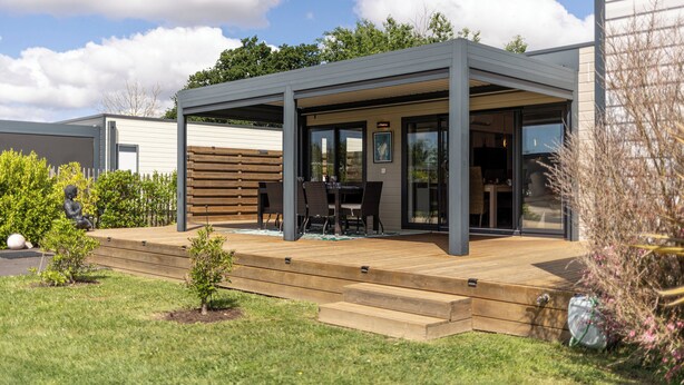 A modern outdoor patio with a wooden deck, a covered seating area, and a view of the backyard. - Your dream getaway just a stone's throw from the beaches of the Vendée! (Sainte-Foy)