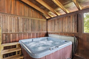 Una cabaña de madera con jacuzzi, paredes de madera y una ventana.