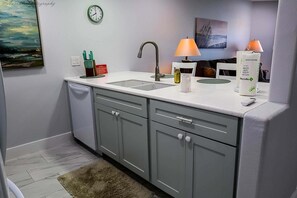 Eine moderne Küche mit Spüle, Schränken und einer Uhr an der Wand.
