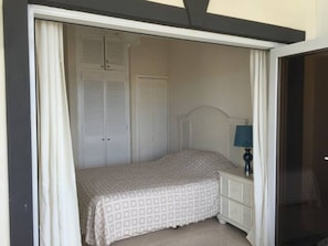 A bedroom with a bed, a nightstand, a lamp, and a wardrobe. - Sea views, one bedroom apartment, Lantana 35 (weston)