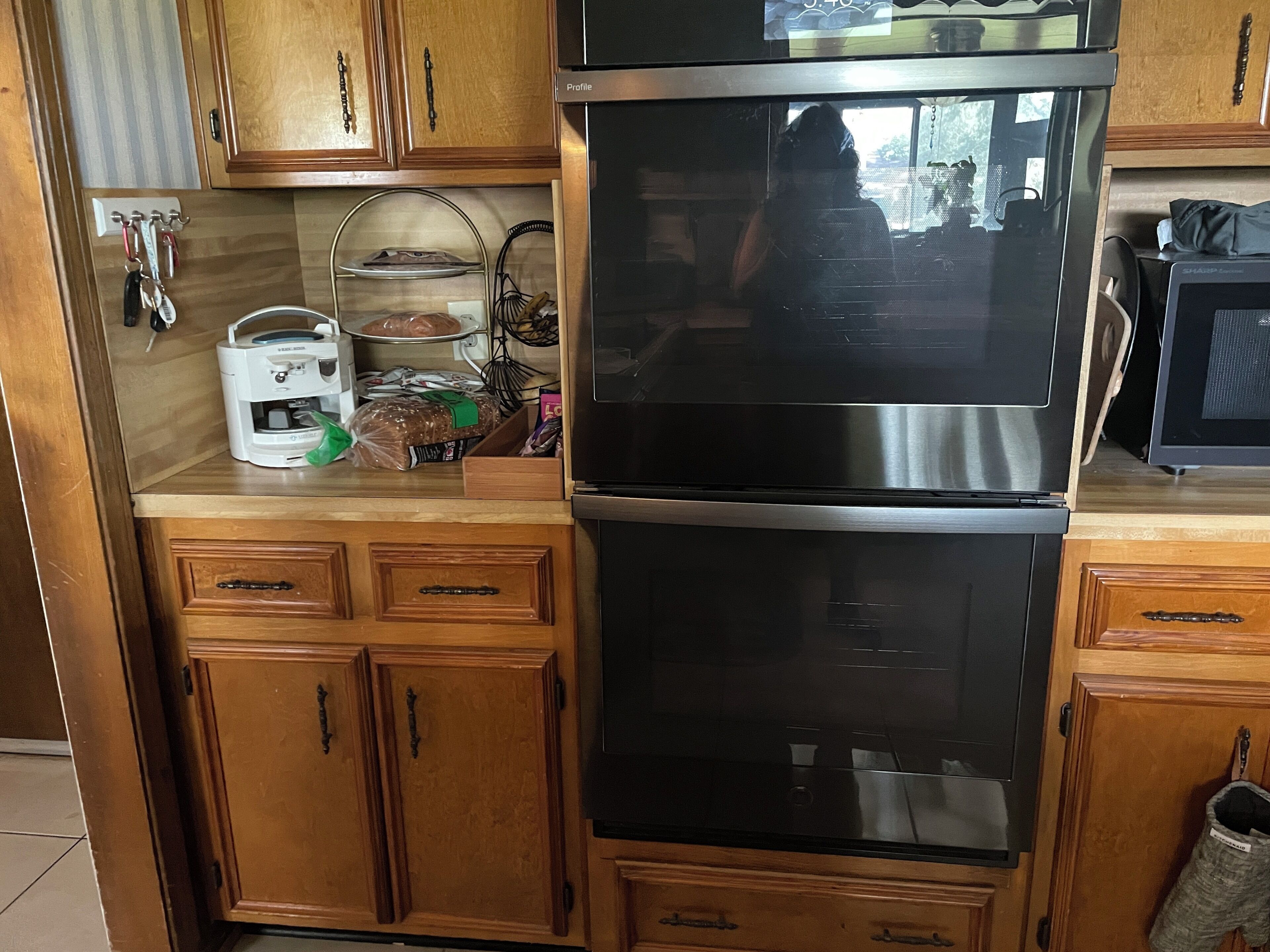Una cocina con armarios de madera, un refrigerador de acero inoxidable y un microondas.