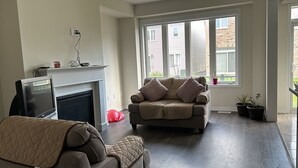 Un salon avec une cheminée, un canapé et un téléviseur.