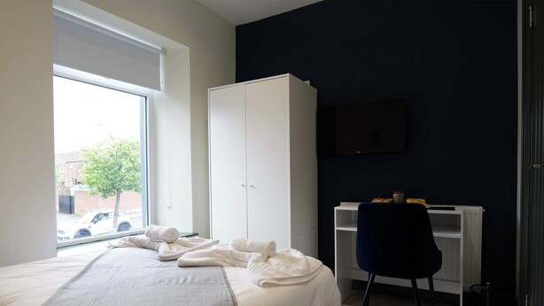 A bedroom with a bed, a wardrobe, a desk, and a TV. - Private Double Room, Shared Bathroom-Walk to City (Derry/Londonderry)