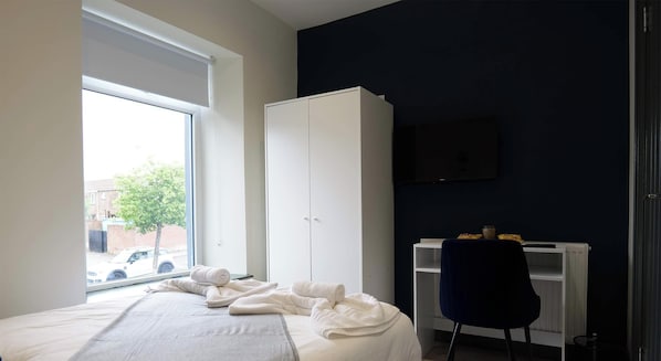 A bedroom with a bed, a wardrobe, a desk, and a TV. - Private Double Room, Shared Bathroom-Walk to City (Derry/Londonderry)