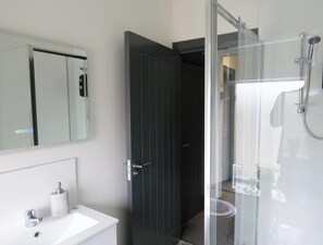 A bathroom with a white sink, a mirror, a toilet, and a shower area. - Private Double Room, Shared Bathroom-Walk to City (Derry/Londonderry)