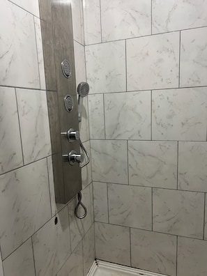 En bruser med håndbruser og kontrolpanel på væggen.