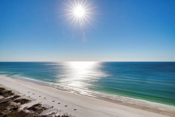 A beach with a clear sky, a bright sun, and a calm sea. - "Heron Walk" Blue Mountain Beach, 30A Condo, Pool, Beach Access (Santa Rosa Beach)