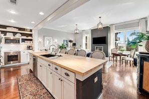 A modern kitchen with a central island, built-in appliances, and a dining area with a view. - "Heron Walk" Blue Mountain Beach, 30A Condo, Pool, Beach Access (Santa Rosa Beach)
