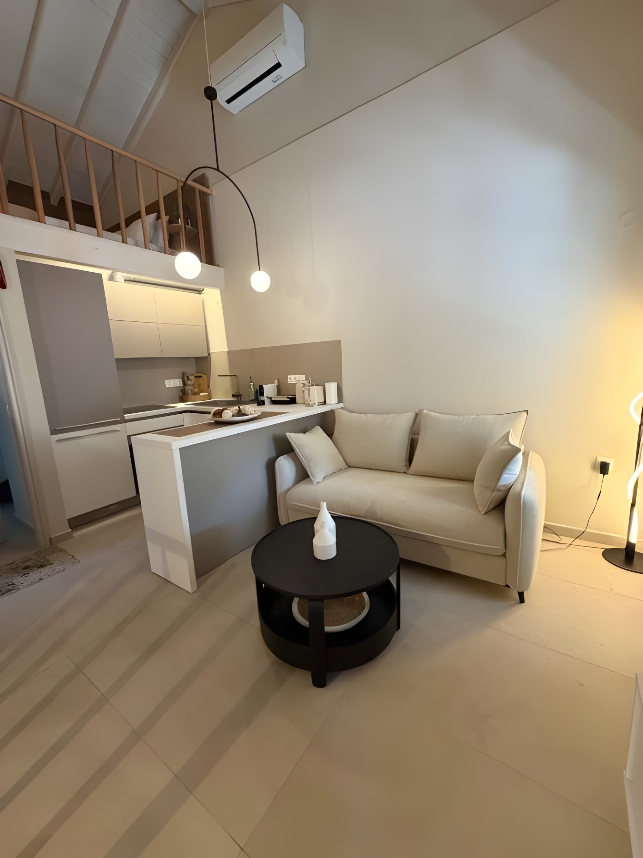 Un espace de vie moderne comprenant une cuisine, un canapé et une table basse ronde.