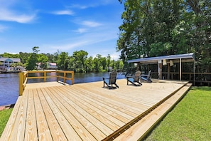 Un pontile di legno con sedie e una zona coperta affacciato su un lago.