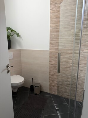 A bathroom with a toilet, bidet, and a glass shower enclosure. - RS Home CB 1 - Stylish apartment for vacation & business (Cottbus)