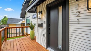 A residential building with a dark front door, a mailbox, and a green planter on the porch. - The EaDo Compound: Main house + Guest House (Houston)