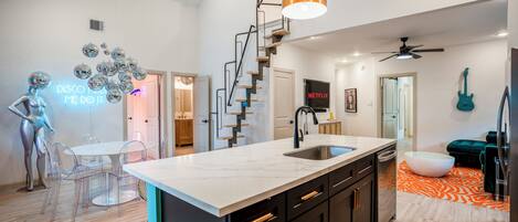 A modern kitchen with a central island, black cabinets, and a white countertop.