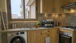 Cocina compacta con lavadora, estufa y lavaplatos.
