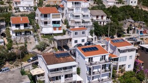 Un quartiere residenziale con edifici a più piani, balconi e pannelli solari sui tetti.