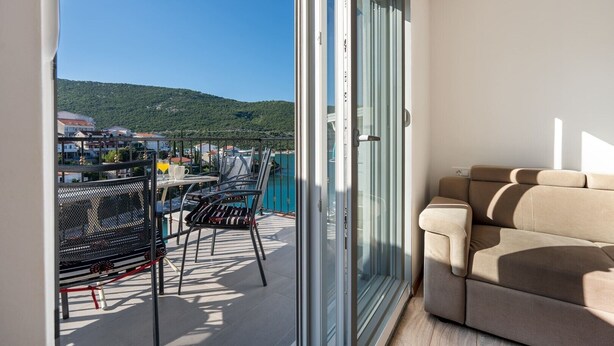 Un balcone con tavolo, sedie e divano.