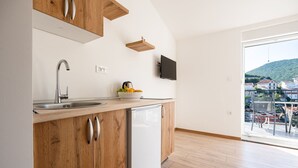 Una cucina con mobili in legno, lavastoviglie integrata, lavello e una ciotola di frutta.