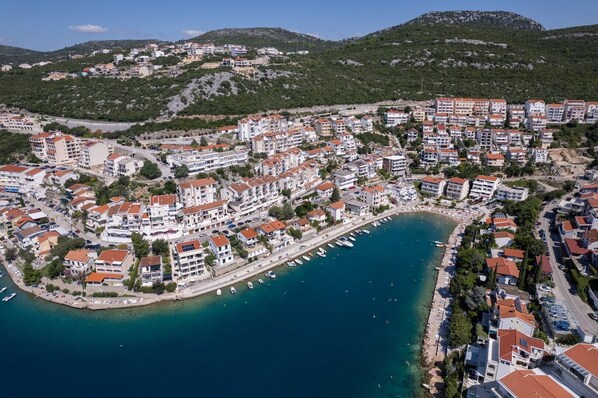 An aerial view of a coastal town with buildings, a marina, and a beach. - Comfortable studio apartment 6 (Neum)