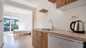 Eine moderne Küche mit Spüle, Wasserkocher und Holzschränken.