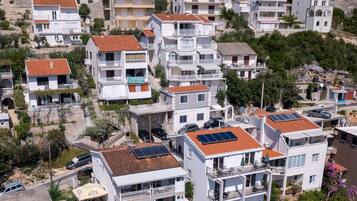 Un quartiere residenziale con edifici a più piani, balconi e pannelli solari sui tetti.