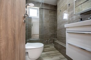 A bathroom with a shower, toilet, and vanity. - Sea view apartment 9 (Neum)