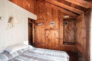 Ein Holzhütten-Interieur mit einem Bett, einer Lampe und einem Schild mit der Aufschrift 'MINE'.
