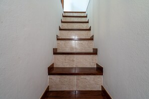 Eine Treppe mit beigen Fliesen und Holzstufen.